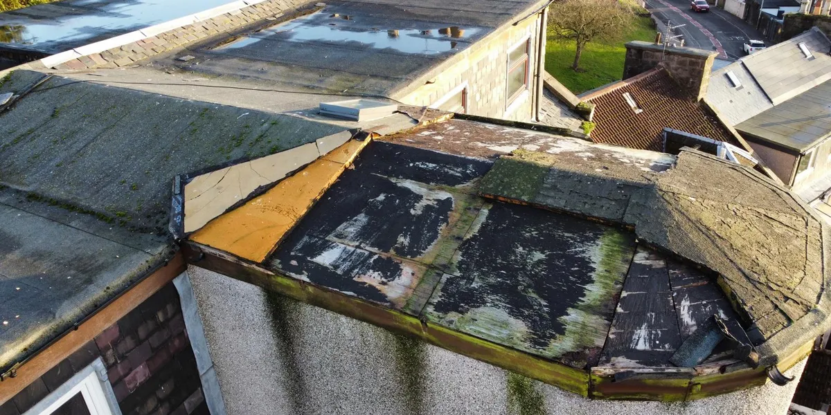 A worn flat roof in Dundee in need of replacement, seen from above