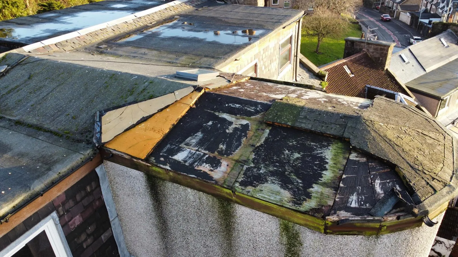 A worn flat roof in Dundee in need of replacement, seen from above