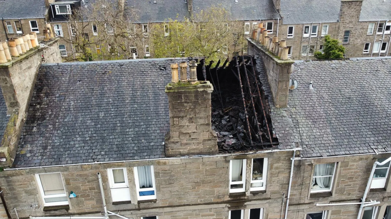 A hole in a Dundee tenement roof exposing the rafters